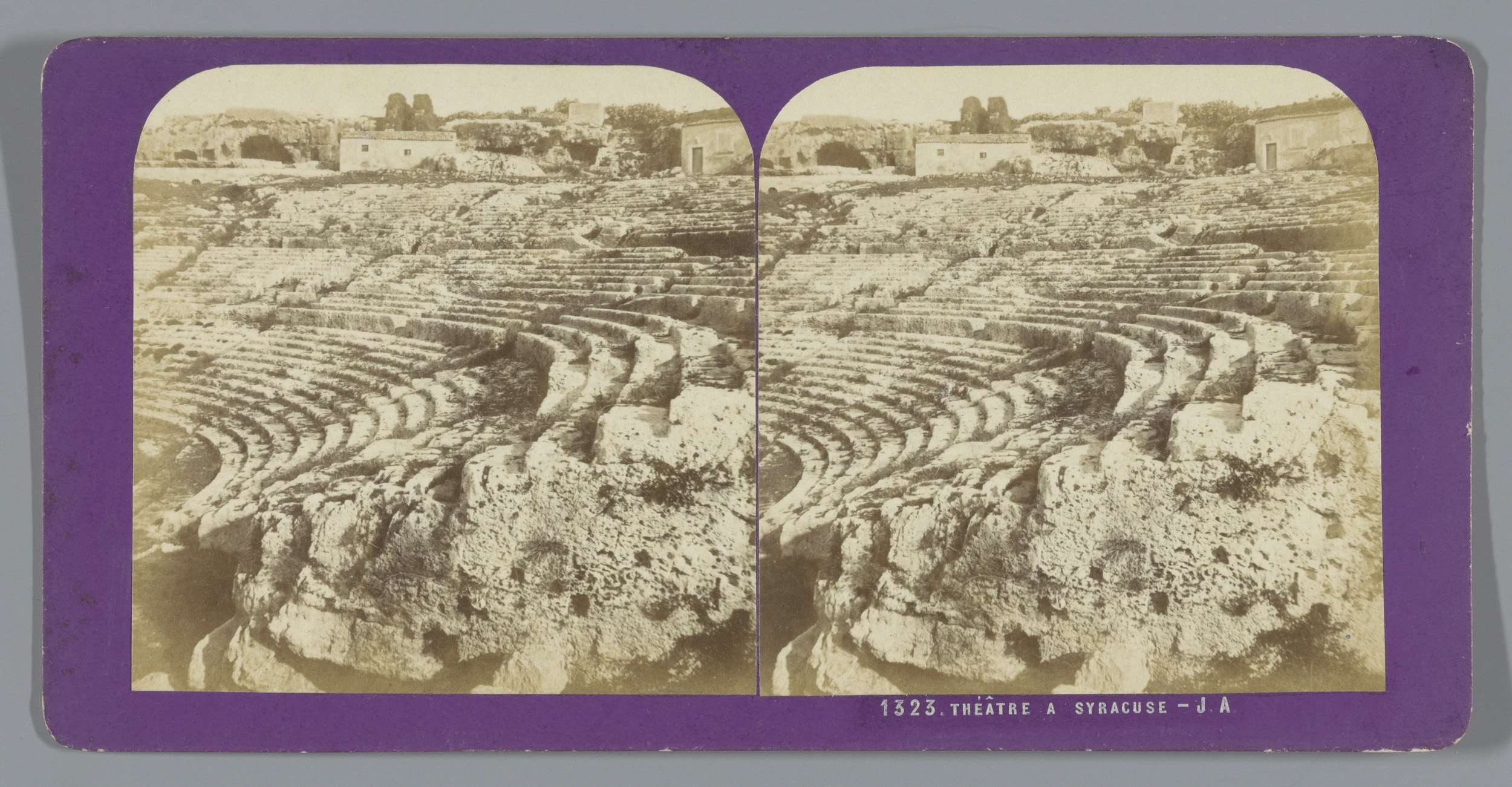 Schwarze und weiße stereoskopische Ansichten des antiken Amphitheaters in Syrakus, die Sitzreihen aus Stein, umgebende Gebäude, Bäume und Himmel mit schwachem Text zeigen.