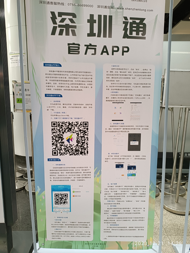 Ein Banner mit einem QR-Code vor einem Gebäude, umgeben von verschiedenen Gegenständen, wahrscheinlich Werbung für den Shenzhen International Airport.