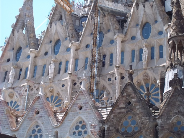 Ein im Bau befindliches Gebäude mit mehreren Skulpturen unter einem klaren Himmel.