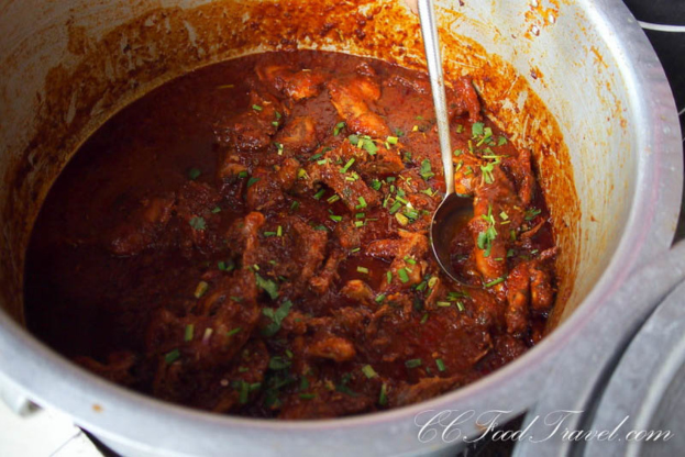 Ein Schüsselchen Fleischcurry mit einem Wasserzeichen in der rechten unteren Ecke.