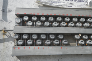 Ein Nahaufnahme eines Elektrizitätszählers, der an der Wand eines Gebäudes montiert ist, mit einem Banner mit Text oben auf dem Bild.