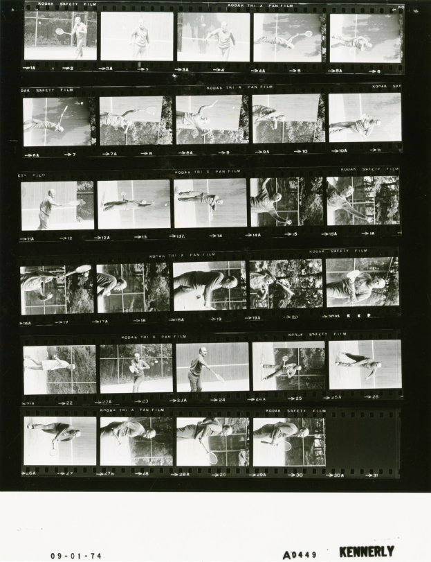 Schwarzes und weißes Foto eines Mannes in einem weißen Hemd und Shorts, der Tennis spielt und einen Schläger hält, mit einem Filmstreifen im Hintergrund und einem konzentrierten Gesichtsausdruck.