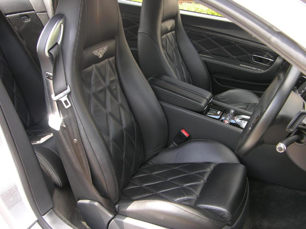 Ein Blick ins Innere eines Autos, das mittlere Sitze und ein Lenkrad auf der rechten Seite zeigt.
