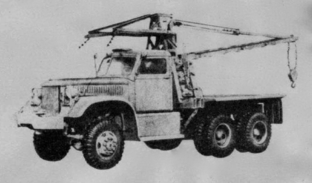 Ein Schwarz-Weiß-Foto eines großen, vierrädrigen Lastwagens mit einem Kran auf der Ladefläche und einem Sattelauflieger.