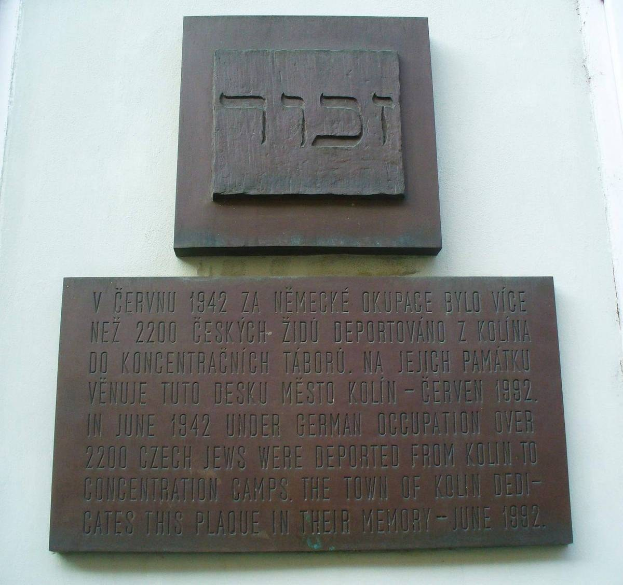 Metallplatte an einer Gebäudewand mit hebräischer Schrift, wahrscheinlich ein Denkmal für jüdische Gemeindeglieder, die dienten.