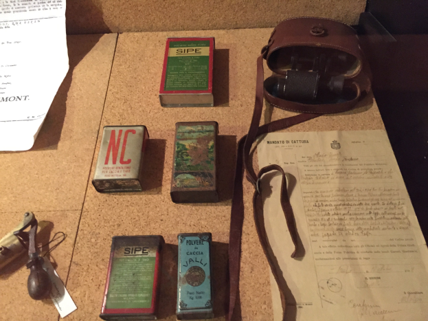 Ein Korkbrett mit verschiedenen Gegenständen, die angeheftet oder angepinnt sind, darunter Schachteln, Papiere und eine Tasche.