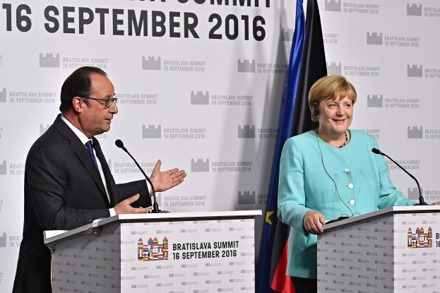 Bundeskanzlerin Angela Merkel und Frankreichs Präsident François Hollande stehen vor zwei Podien mit Mikrofonen, beide lachend, mit einem Banner im Hintergrund mit der Aufschrift "Bratislava-Gipfel 2016".