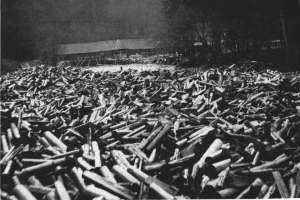 Ein Schwarz-Weiß-Foto eines großen Haufens von Kugeln im Vordergrund, mit einer Hütte und Bäumen im Hintergrund; der Text unten lautet "Zweiter Weltkrieg".