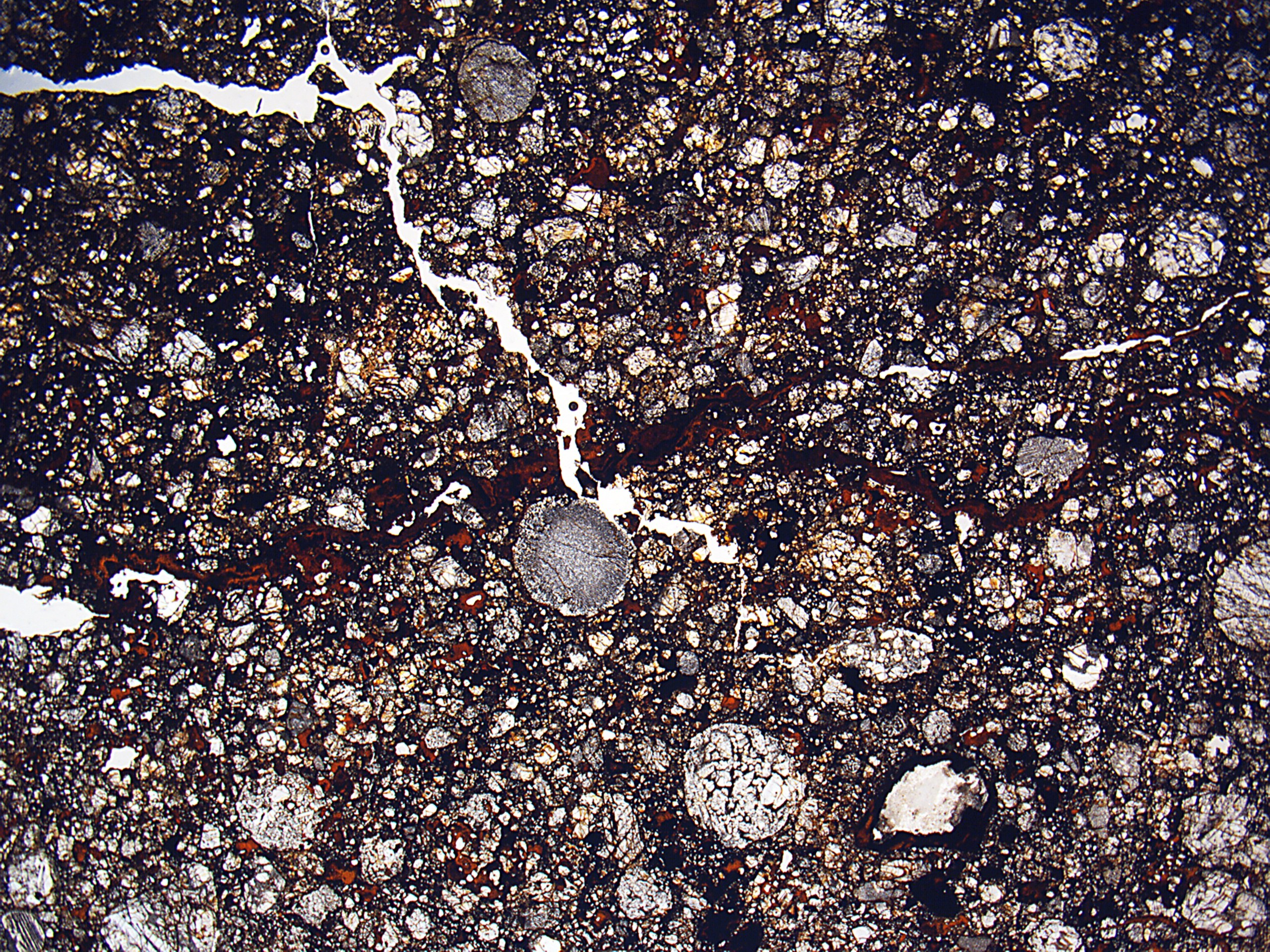 Nahaufnahme einer gesprungenen, schmutzigen Straße mit einer rauen, unebenen Oberfläche.