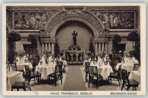 Ein altes Schwarz-Weiß-Foto eines Berliner Restaurants mit Tischen, Stühlen, Blumenvasen, einer Statue, Skulpturen und Pflanzen an den Wänden, mit Text unten.