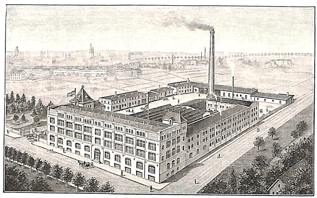 Alte Fabrik mit großem zentralen Gebäude umgeben von Bäumen und Text unten.