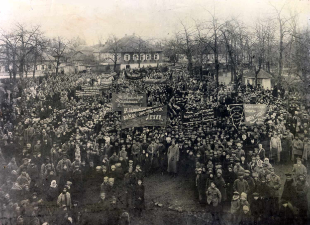 Eine große Menge von Menschen mit Schildern steht vor einem Gebäude, mit Bäumen und Gebäuden mit Fenstern im Hintergrund, auf einem Schwarz-Weiß-Bild, das einen Protest gegen die Sowjetunion vermuten lässt.