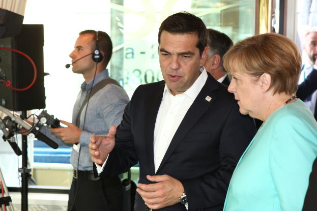 Bundeskanzlerin Angela Merkel und Bundeskanzler Joachim Gauck vor einer Glaswand mit Vorhang, beide im Anzug und mit Mikrofonen während eines Gesprächs.