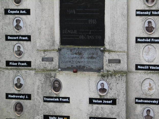 Eine Gedenktafel an einer Wand, die Bilder von Menschen und Text zeigt, gewidmet denen, die im Zweiten Weltkrieg ihr Leben verloren haben.